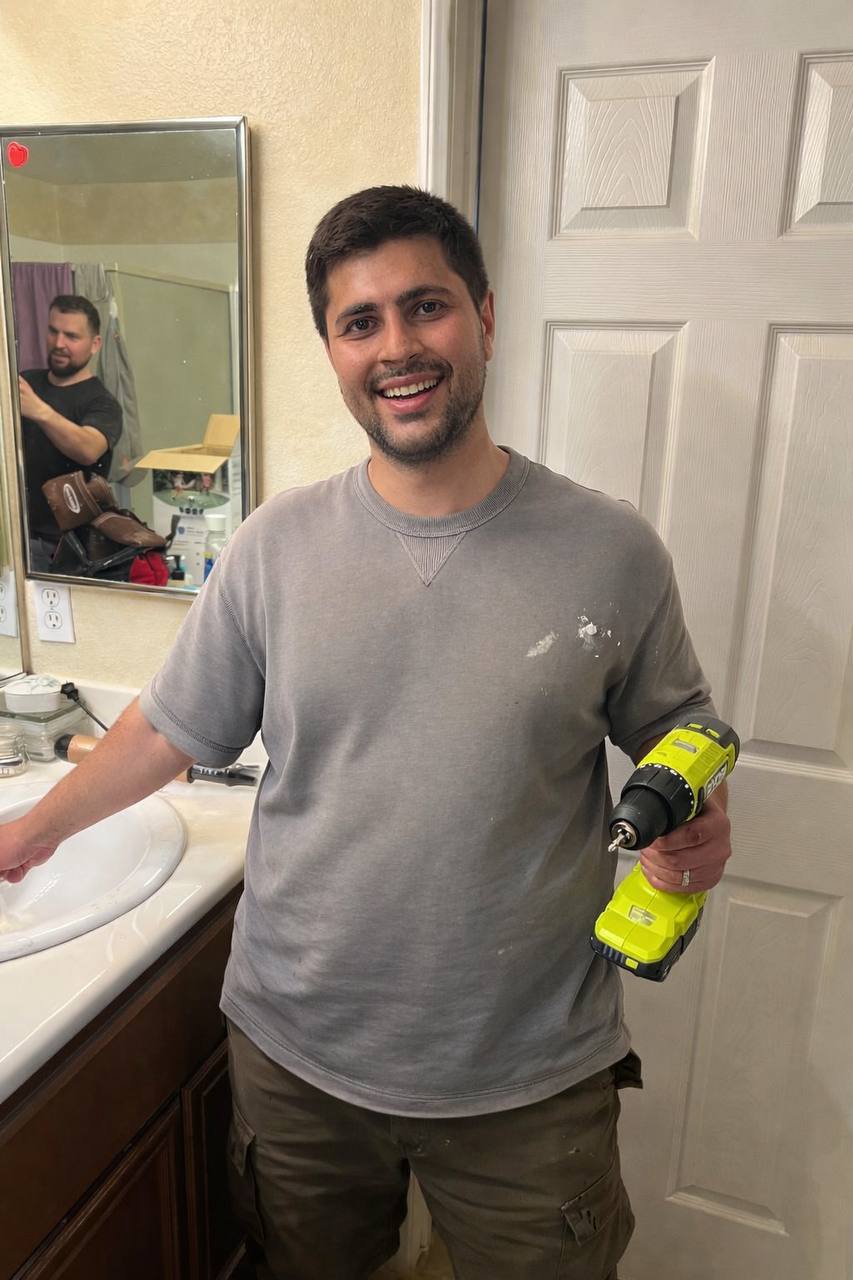 Hovhannes holding a drill while installing cameras in a customer's home in Los Angeles